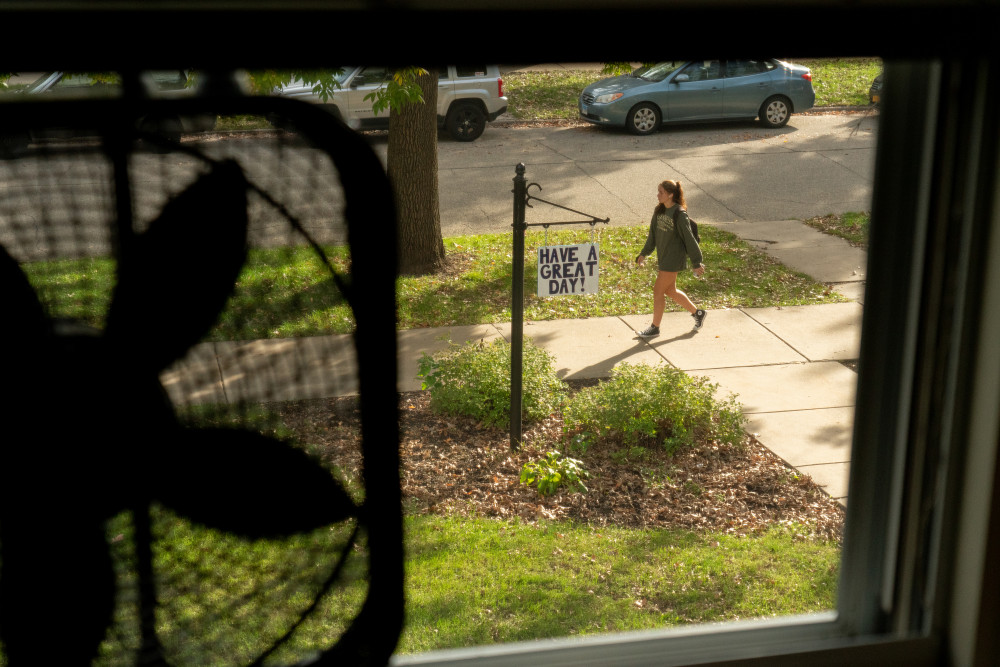 The view out of a student's dorm room window, looking at a sign reading, have a great day.