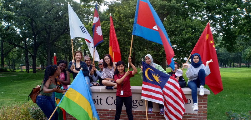 毕业典礼后，国际学生在伯洛伊特学院的指示牌前挥舞旗帜。