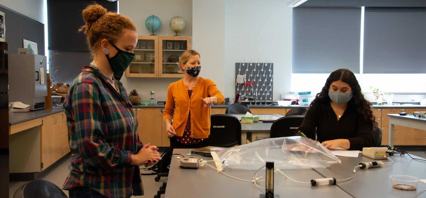 生物学教授唐娅·凯里带领学生在实验室里进行实践学习，并保持适当的距离和清洁，