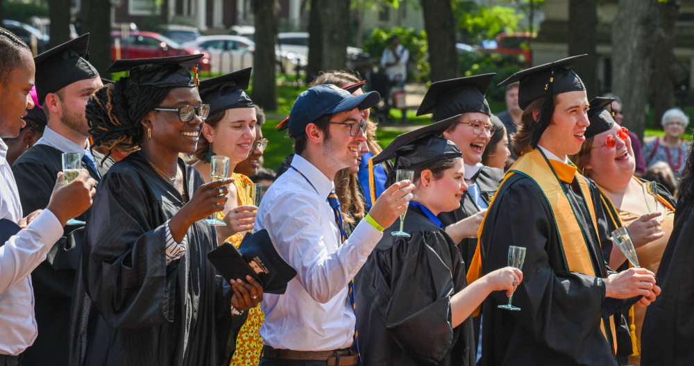 2020届毕业生站起来，准备喝香槟庆祝他们的成就。