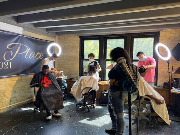 Students getting free haircuts from ClipDart barbers. 