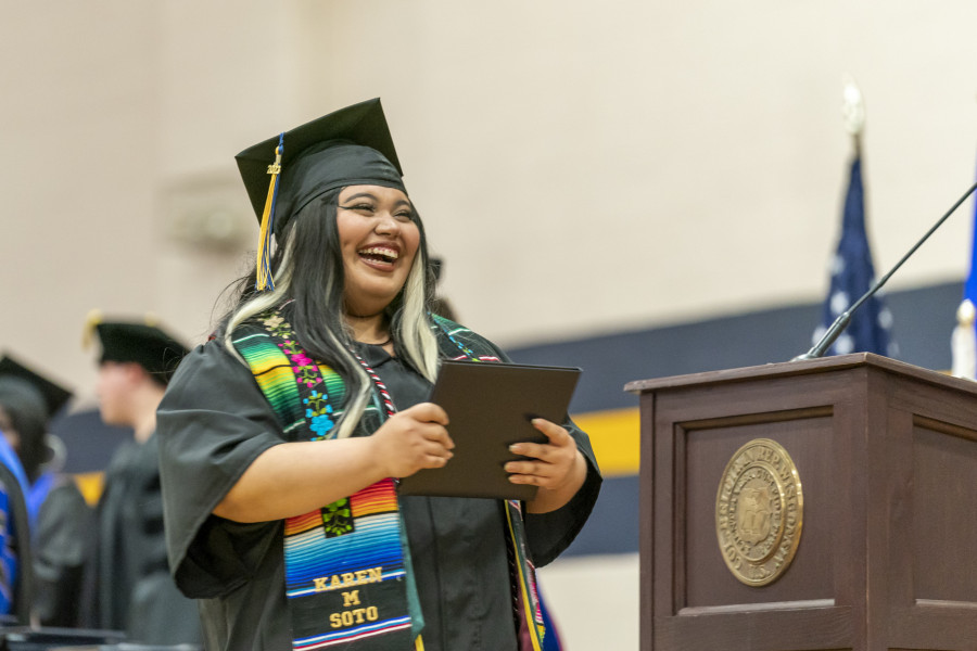 2023年毕业典礼上，一名学生微笑着接受毕业证书。