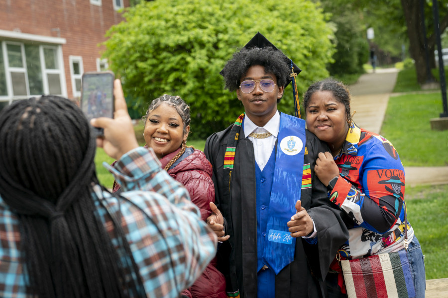 一位毕业生和他们的家人一起摆姿势拍照。
