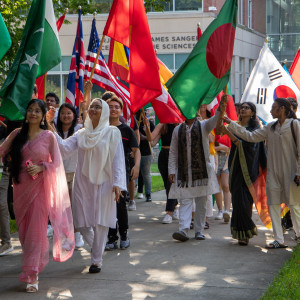 留学生们举着各自国家的国旗，走在毕业典礼游行队伍的最前面。