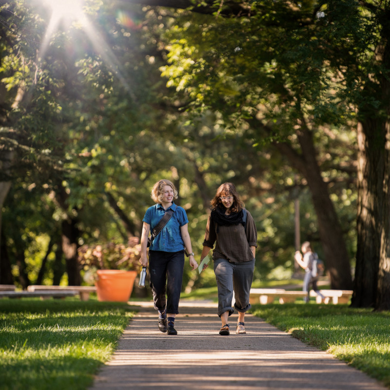 Two students walking together across campus.