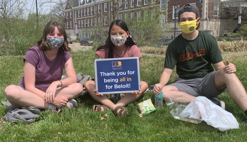 学生们坐在草地上，举着一个牌子，上面写着“谢谢你为贝洛伊特付出一切”。