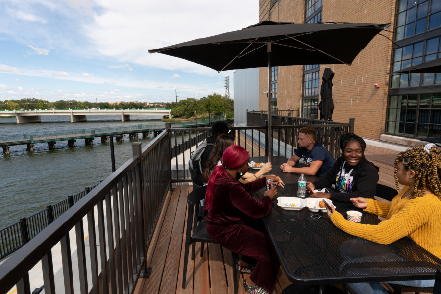 Students eating on the Powerhouse's terrace alongside the Rock River