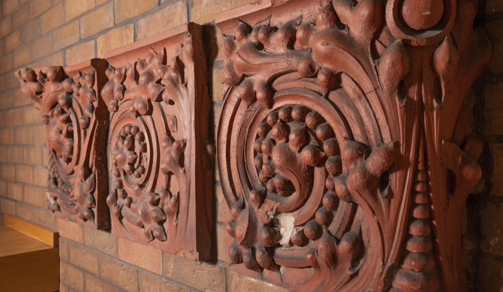 Neese剧院的主大厅有三个雕刻的陶土瓷砖安装在砖墙上。
