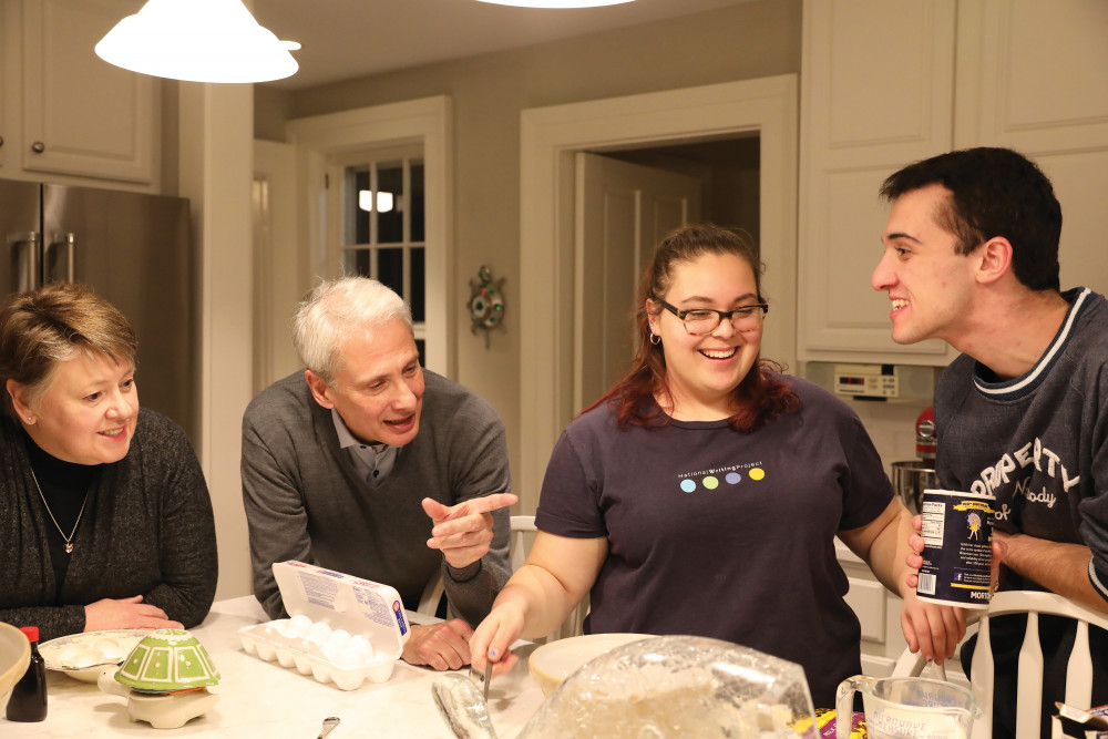 Melody and Scott Bierman work with two students to make cookies in their home.