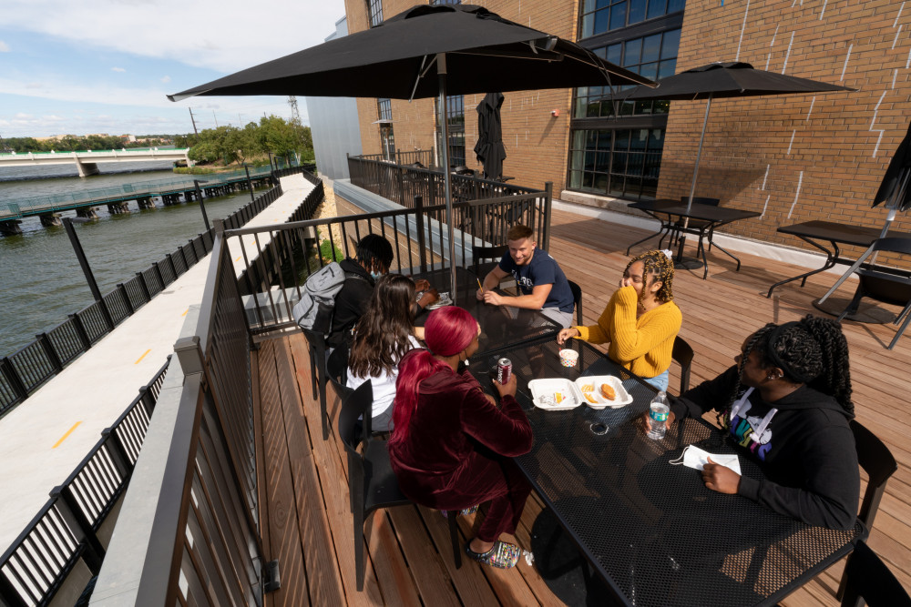 能看到海滨景色的桌子。学生们在建筑的屋顶上享受充足的聚会空间。