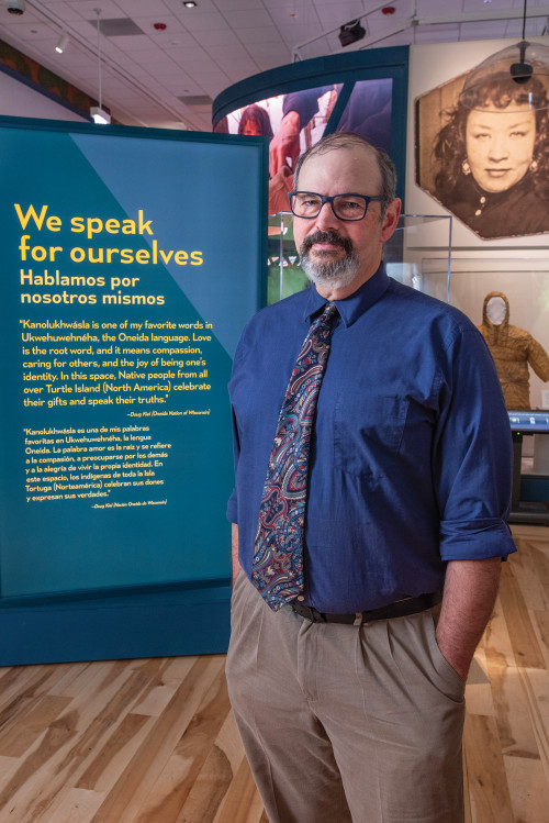 Tom Skwerski'87 stands at the entrance of the Native Truths exhibit.